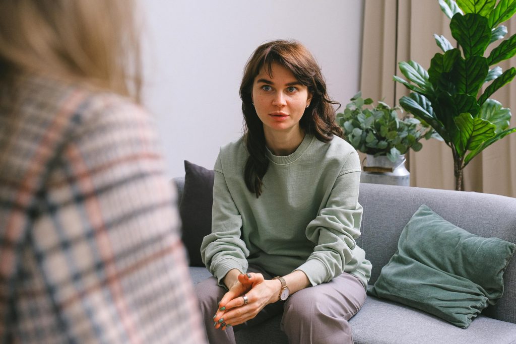 pexels photo 7176297 7176297 A focused woman during a therapy session, seated on a sofa indoors.