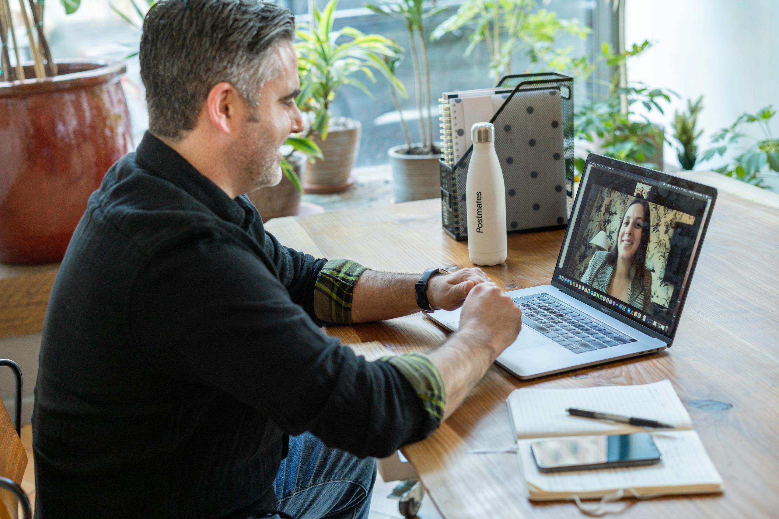 🌐 Miért érdemes online, Zoom randira menni? A man participates in a virtual meeting from his home workspace, focusing on remote work.